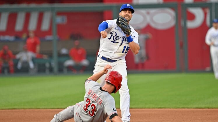 Jul 5, 2021; Kansas City, Missouri, USA;  Kansas City Royals second baseman Whit Merrifield (15) completes a double play with a throw to first over Cincinnati Reds designated hitter Jesse Winker (33) during the fourth inning at Kauffman Stadium. Mandatory Credit: Peter Aiken-USA TODAY Sports