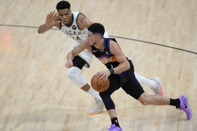 Jul 6, 2021; Phoenix, Arizona, USA; Phoenix Suns guard Devin Booker (1) moves the ball against Milwaukee Bucks forward Giannis Antetokounmpo (34) during the second half in game one of the 2021 NBA Finals at Phoenix Suns Arena. Mandatory Credit: Joe Camporeale-USA TODAY Sports