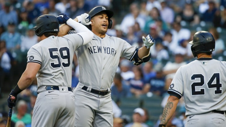 Jul 6, 2021; Seattle, Washington, USA; New York Yankees designated hitter Giancarlo Stanton (27) bumps forearms with first baseman Luke Voit (59) following a three-run home run against the Seattle Mariners during the first inning at T-Mobile Park. Mandatory Credit: Joe Nicholson-USA TODAY Sports