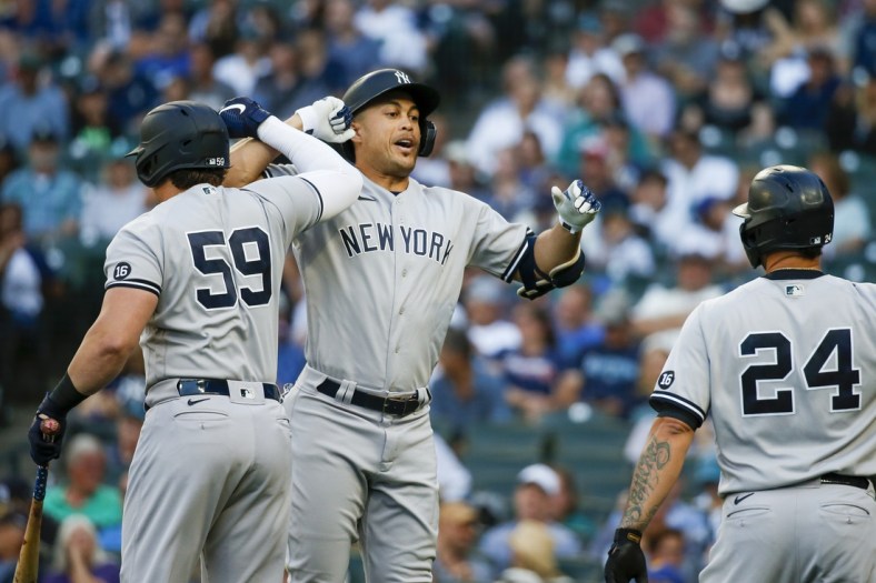 Jul 6, 2021; Seattle, Washington, USA; New York Yankees designated hitter Giancarlo Stanton (27) bumps forearms with first baseman Luke Voit (59) following a three-run home run against the Seattle Mariners during the first inning at T-Mobile Park. Mandatory Credit: Joe Nicholson-USA TODAY Sports