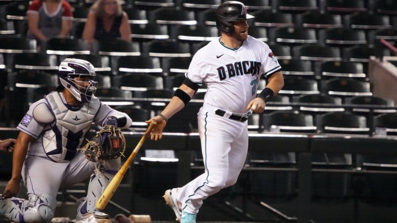 Jul 6, 2021; Phoenix, Arizona, USA; Arizona Diamondbacks catcher Stephen Vogt (21) hits a single against the Colorado Rockies in the ninth inning at Chase Field. Mandatory Credit: Rick Scuteri-USA TODAY Sports