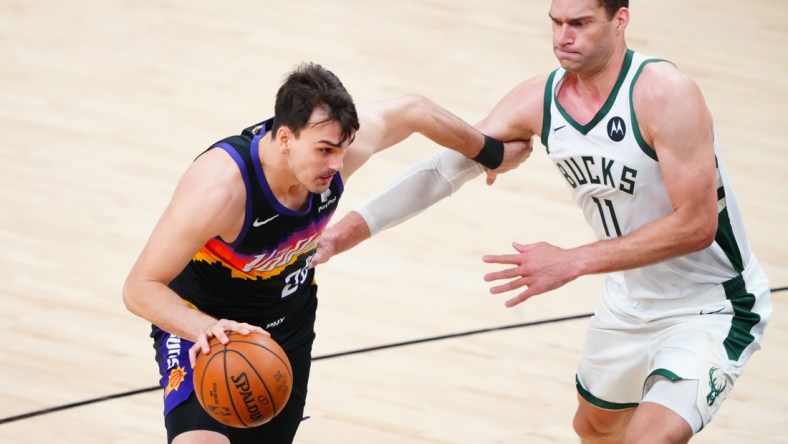 Jul 6, 2021; Phoenix, Arizona, USA; Phoenix Suns forward Dario Saric (20) drives to the basket against Milwaukee Bucks center Brook Lopez (11) during game one of the 2021 NBA Finals at Phoenix Suns Arena. Mandatory Credit: Mark J. Rebilas-USA TODAY Sports