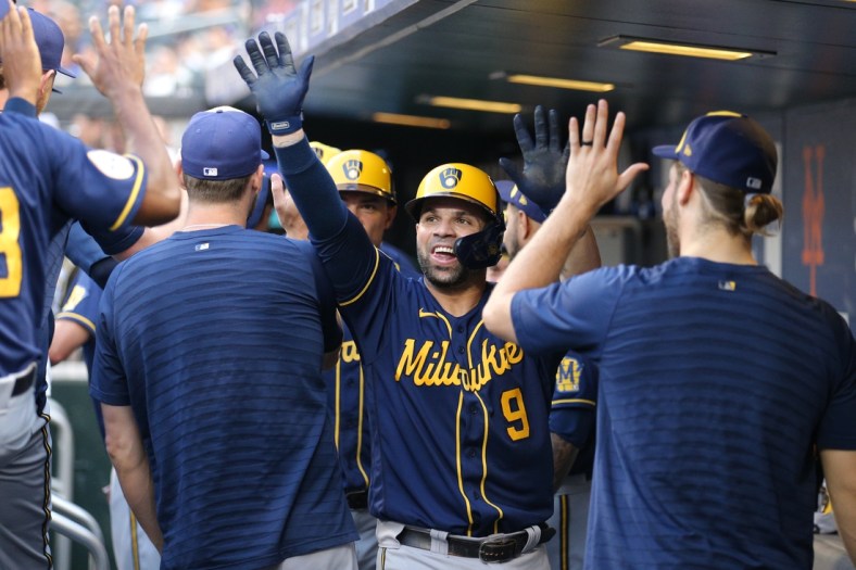 Jul 7, 2021; New York City, New York, USA; Milwaukee Brewers catcher Manny Pina (9) celebrates in the dugout with teammates after hitting a two run home run against the New York Mets during the second inning at Citi Field. Mandatory Credit: Brad Penner-USA TODAY Sports