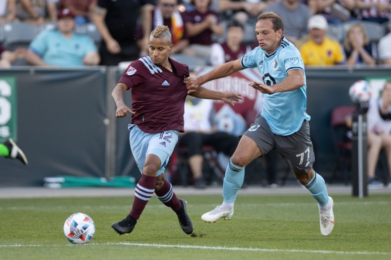 Jul 7, 2021; Commerce City, Colorado, USA; Colorado Rapids forward Michael Barrios (12) and Minnesota United FC defender Chase Gasper (77) battle for the ball in the first half at Dick's Sporting Goods Park. Mandatory Credit: Isaiah J. Downing-USA TODAY Sports