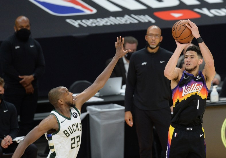 Jul 8, 2021; Phoenix, Arizona, USA; Phoenix Suns guard Devin Booker (1) shoots against Milwaukee Bucks forward Khris Middleton (22) during the second half in game two of the 2021 NBA Finals at Phoenix Suns Arena. Mandatory Credit: Joe Camporeale-USA TODAY Sports