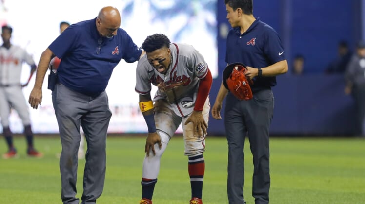 Jul 10, 2021; Miami, Florida, USA; Atlanta Braves right fielder Ronald Acuna Jr. (13) reacts as he gets check on by training staff after an apparent leg injury during the fifth inning  against the Miami Marlins at loanDepot Park. Mandatory Credit: Sam Navarro-USA TODAY Sports