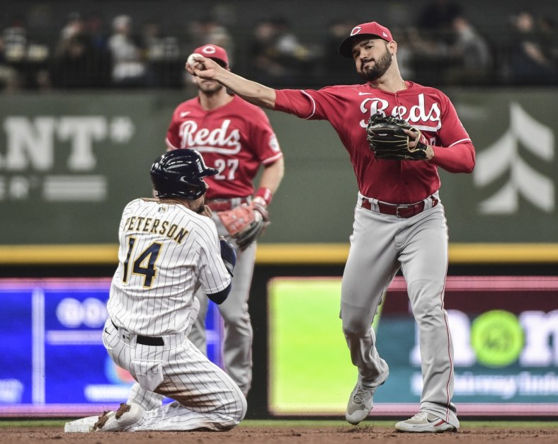 Jul 11, 2021; Milwaukee, Wisconsin, USA; Milwaukee Brewers second baseman Jace Peterson (14) breaks up a double play attempt by Cincinnati Reds third baseman Eugenio Suarez (7) in the second inning at American Family Field. Mandatory Credit: Benny Sieu-USA TODAY Sports