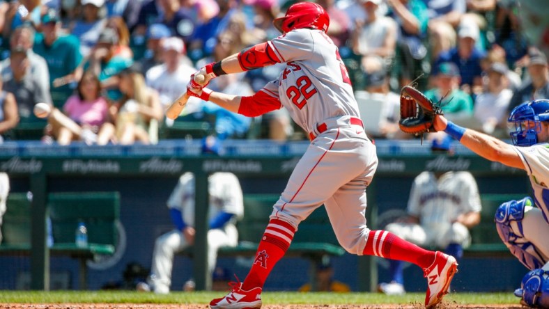 Jul 11, 2021; Seattle, Washington, USA; Los Angeles Angels second baseman David Fletcher (22) hits a two-run RBI single against the Seattle Mariners during the fifth inning at T-Mobile Park. Mandatory Credit: Jennifer Buchanan-USA TODAY Sports