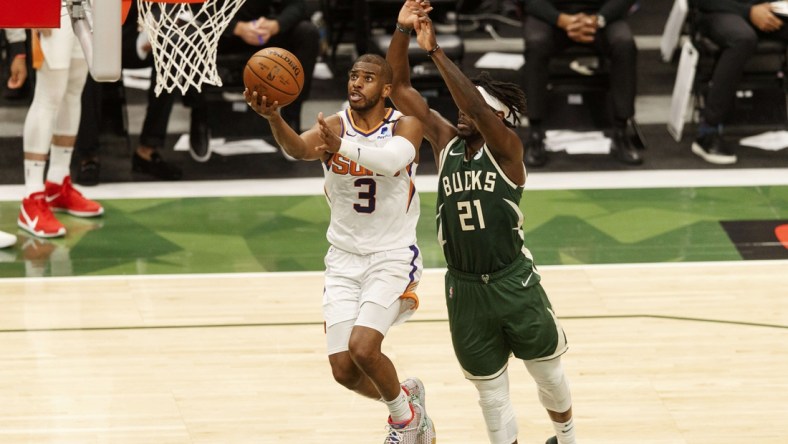 Jul 11, 2021; Milwaukee, Wisconsin, USA; Phoenix Suns guard Chris Paul (3) drives for a layup against Milwaukee Bucks guard Jrue Holiday (21) during the third quarter during game three of the 2021 NBA Finals at Fiserv Forum. Mandatory Credit: Jeff Hanisch-USA TODAY Sports