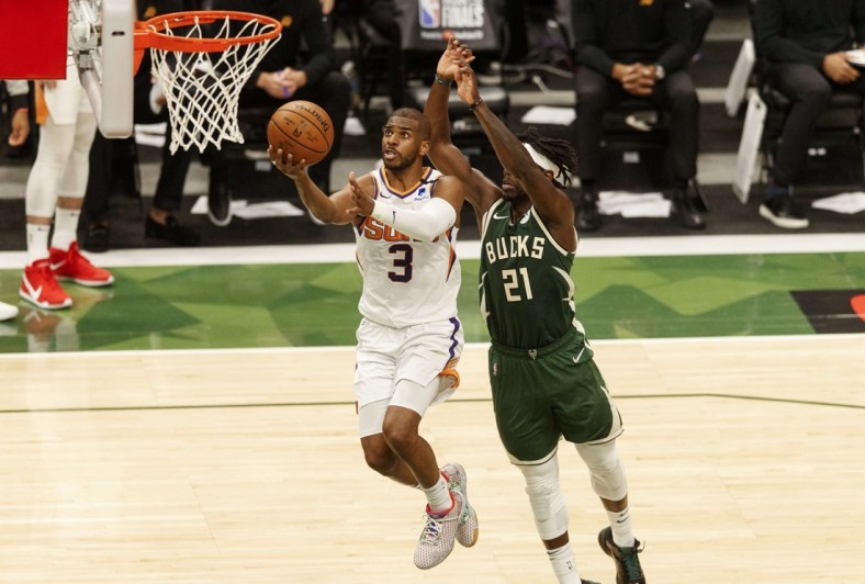 Jul 11, 2021; Milwaukee, Wisconsin, USA; Phoenix Suns guard Chris Paul (3) drives for a layup against Milwaukee Bucks guard Jrue Holiday (21) during the third quarter during game three of the 2021 NBA Finals at Fiserv Forum. Mandatory Credit: Jeff Hanisch-USA TODAY Sports