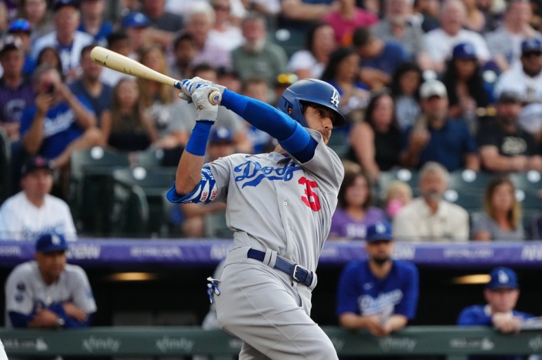 Jul 16, 2021; Denver, Colorado, USA; Los Angeles Dodgers center fielder Cody Bellinger (35) hits a two run RBI single in the first inning against the Colorado Rockies at Coors Field. Mandatory Credit: Ron Chenoy-USA TODAY Sports