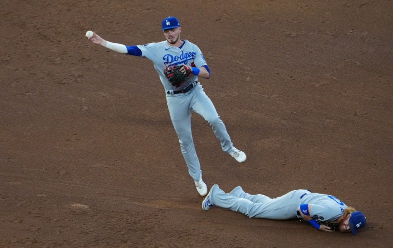 Jul 16, 2021; Denver, Colorado, USA; Los Angeles Dodgers short stop Gavin Lux (9) fields the ball over third baseman Justin Turner (10) in the fourth inning against the Colorado Rockies at Coors Field. Mandatory Credit: Ron Chenoy-USA TODAY Sports