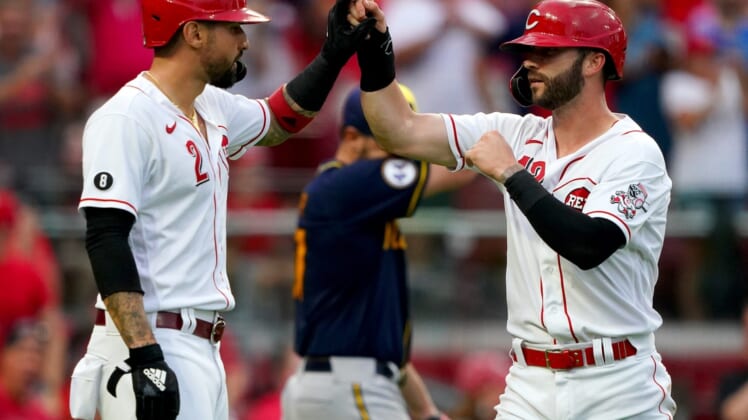 Cincinnati Reds center fielder Tyler Naquin (12) is congratulated by Cincinnati Reds right fielder Nick Castellanos (2) after the two scored during the third inning of a baseball game against the Milwaukee Brewers, Friday, July 16, 2021, at Great American Ball Park in Cincinnati. The Milwaukee Brewers won, 11-6.Milwaukee Brewers At Cincinnati Reds July 16