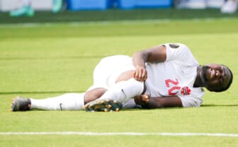Jul 18, 2021; Kansas City, Kansas, USA; Canada forward Ayo Akinola (20) lays on the field after an injury in the game against the United States during the CONCACAF Gold Cup Soccer group stage play at Children's Mercy Park. Mandatory Credit: Denny Medley-USA TODAY Sports