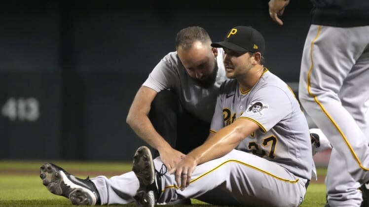 Jul 19, 2021; Phoenix, Arizona, USA; Pittsburgh Pirates starting pitcher Chase De Jong (37) gets checked by the trainer in the third inning against the Arizona Diamondbacks at Chase Field. Mandatory Credit: Rick Scuteri-USA TODAY Sports