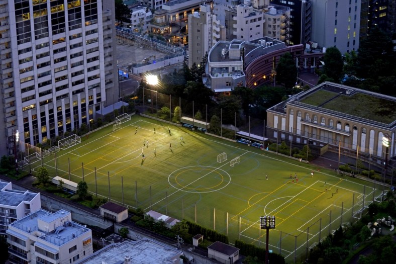 Jul 20, 2021; Tokyo, Japan; People play soccer on a field near the Tokyo Tower before the Tokyo 2020 Summer Olympic Games. Mandatory Credit: Peter Casey-USA TODAY Network