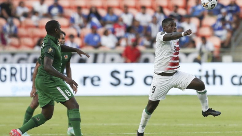 Jul 20, 2021; Houston, Texas, USA; Suriname  forward Nigel Hasselbaink (9) heads the ball against Guadeloupe in the second half during a CONCACAF Gold Cup group stage soccer match at BBVA Stadium. Mandatory Credit: Thomas Shea-USA TODAY Sports