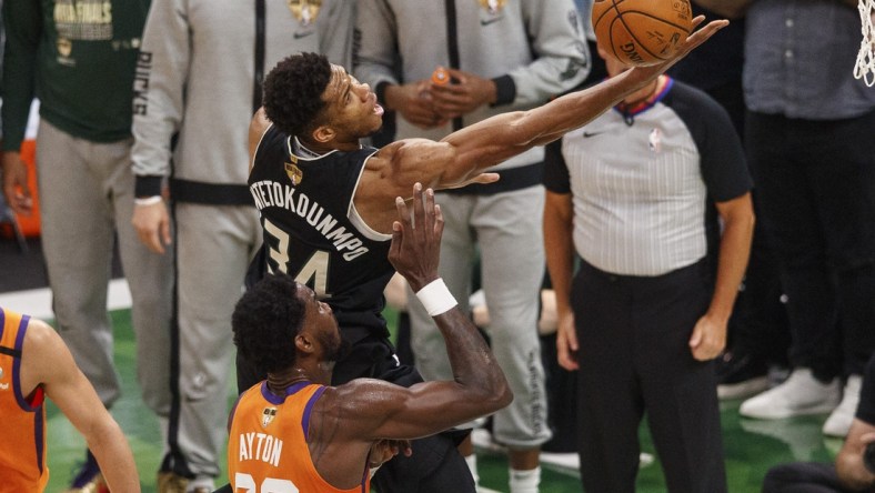 Jul 20, 2021; Milwaukee, Wisconsin, USA; Milwaukee Bucks forward Giannis Antetokounmpo (34) shoots over Phoenix Suns center Deandre Ayton (22) during the third quarter during game six of the 2021 NBA Finals at Fiserv Forum. Mandatory Credit: Jeff Hanisch-USA TODAY Sports