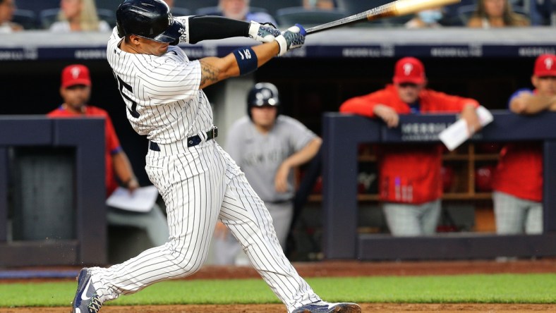 Jul 21, 2021; Bronx, New York, USA; New York Yankees shortstop Gleyber Torres (25) hits a solo home run against the Philadelphia Phillies during the fourth inning at Yankee Stadium. Mandatory Credit: Andy Marlin-USA TODAY Sports