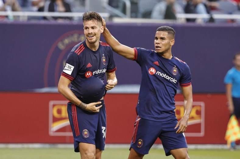 Jul 21, 2021; Chicago, Illinois, USA; Chicago Fire midfielder Gaston Gimenez (30) celebrates with defender Miguel Angel Navarro (6) after scoring against D.C. United during the first half of MLS game at Soldier Field. Mandatory Credit: Kamil Krzaczynski-USA TODAY Sports
