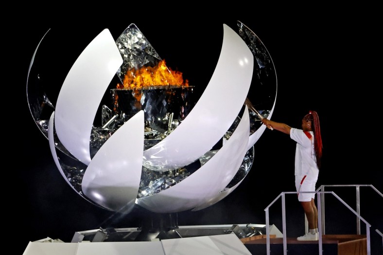 Jul 23, 2021; Tokyo, Japan; Naomi Osaka lights the Olympic flames during the opening ceremony for Tokyo 2020 Olympic Summer Games at Olympic Stadium. Mandatory Credit: Geoff Burke-USA TODAY Sports