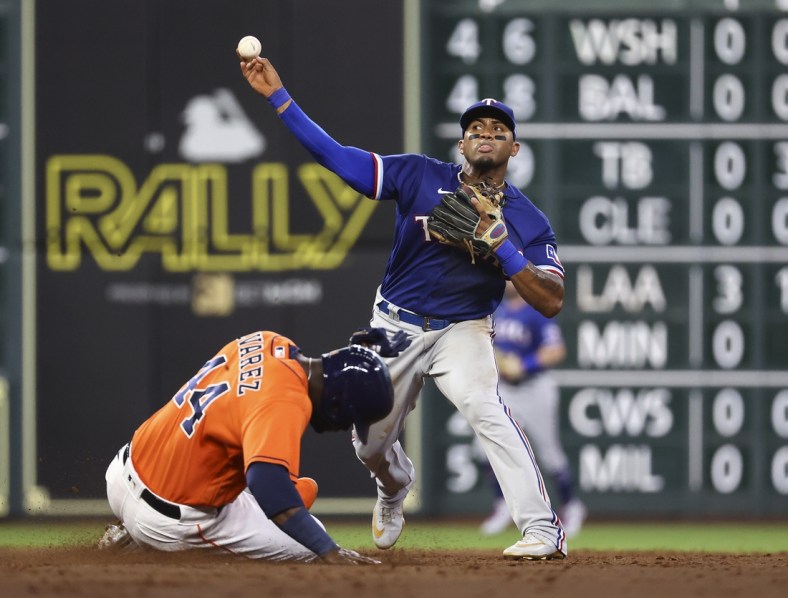 Jul 23, 2021; Houston, Texas, USA; Houston Astros designated hitter Yordan Alvarez (44) is out at second base as Texas Rangers second baseman Andy Ibanez (77) throws to first base during the third inning at Minute Maid Park. Mandatory Credit: Troy Taormina-USA TODAY Sports