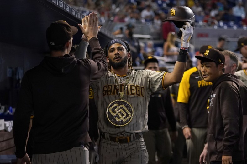 Jul 24, 2021; Miami, Florida, USA; San Diego Padres shortstop Fernando Tatis Jr. (23) celebrates his solo homerun in the dugout while wearing the swag chain in the 1st inning against the Miami Marlins at loanDepot park. Mandatory Credit: Jasen Vinlove-USA TODAY Sports