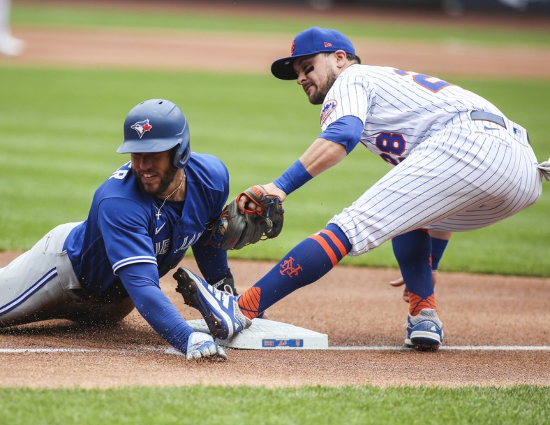Jul 25, 2021; New York City, New York, USA;  Toronto Blue Jays center fielder George Springer (4) is tagged out trying to steal third base by New York Mets third baseman J.D. Davis (28) in the first inning at Citi Field. Mandatory Credit: Wendell Cruz-USA TODAY Sports