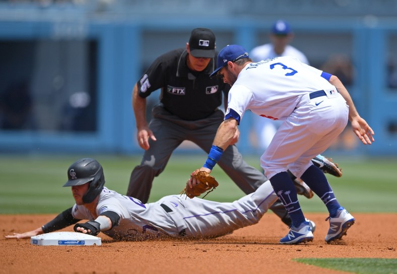 Jul 25, 2021; Los Angeles, California, USA;  Colorado Rockies shortstop Trevor Story (27) is tagged by Los Angeles Dodgers shortstop Chris Taylor (3) as he is caught in a run down play in the second inning at Dodger Stadium. Mandatory Credit: Jayne Kamin-Oncea-USA TODAY Sports