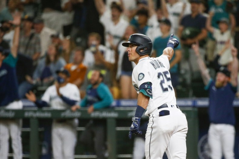 Jul 26, 2021; Seattle, Washington, USA; Seattle Mariners shortstop Dylan Moore (25) hits a grand-slam home run against the Houston Astros during the eighth inning at T-Mobile Park. Mandatory Credit: Joe Nicholson-USA TODAY Sports