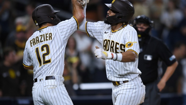 Jul 27, 2021; San Diego, California, USA; San Diego Padres shortstop Fernando Tatis Jr. (right) is congratulated by left fielder Adam Frazier (12) after hitting a two-run home run against the Oakland Athletics during the third inning at Petco Park. Mandatory Credit: Orlando Ramirez-USA TODAY Sports