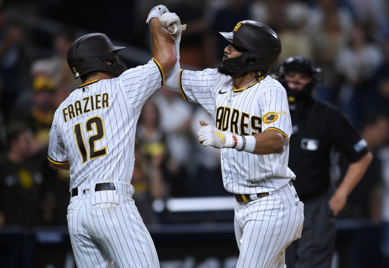 Jul 27, 2021; San Diego, California, USA; San Diego Padres shortstop Fernando Tatis Jr. (right) is congratulated by left fielder Adam Frazier (12) after hitting a two-run home run against the Oakland Athletics during the third inning at Petco Park. Mandatory Credit: Orlando Ramirez-USA TODAY Sports