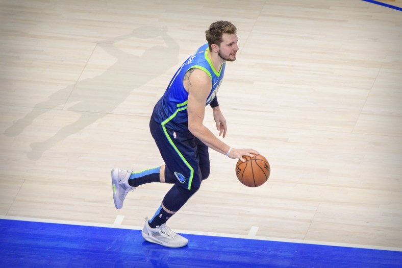 Jan 8, 2020; Dallas, Texas, USA; Dallas Mavericks forward Luka Doncic (77) and the shadow outline of former player Dirk Nowitzki during the game between the Mavericks and the Nuggets at the American Airlines Center. Mandatory Credit: Jerome Miron-USA TODAY Sports