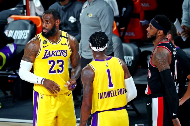 Aug 29, 2020; Lake Buena Vista, Florida, USA; Los Angeles Lakers forward LeBron James (23) talks to guard Kentavious Caldwell-Pope (1) as Portland Trail Blazers forward Carmelo Anthony (00) looks on during the third quarter in game five of the first round of the 2020 NBA Playoffs at AdventHealth Arena. Mandatory Credit: Kim Klement-USA TODAY Sports