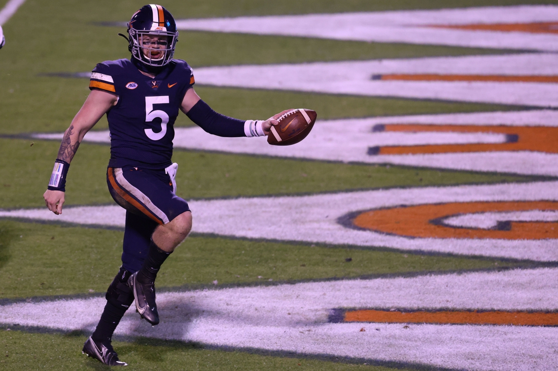 Nov 14, 2020; Charlottesville, Virginia, USA; Virginia Cavaliers quarterback Brennan Armstrong (5) celebrates after scoring a touchdown against the Louisville Cardinals in the fourth quarter at Scott Stadium. Mandatory Credit: Geoff Burke-USA TODAY Sports