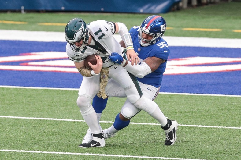 Nov 15, 2020; East Rutherford, New Jersey, USA; Philadelphia Eagles quarterback Carson Wentz (11) is sacked by New York Giants defensive tackle B.J. Hill (95) during the first half at MetLife Stadium. Mandatory Credit: Vincent Carchietta-USA TODAY Sports