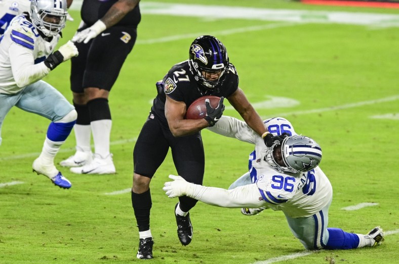 Dec 8, 2020; Baltimore, Maryland, USA; Baltimore Ravens running back J.K. Dobbins (27) stiff arms Dallas Cowboys defensive tackle Neville Gallimore (96) during the second half  at M&T Bank Stadium. Mandatory Credit: Tommy Gilligan-USA TODAY Sports