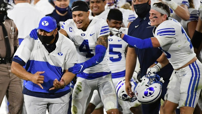 Dec 22, 2020; Boca Raton, Florida, USA; Brigham Young Cougars head coach Kalani Sitake celebrates with defensive back Troy Warner (4) after defeating the UCF Knights at FAU Stadium. Mandatory Credit: Jasen Vinlove-USA TODAY Sports