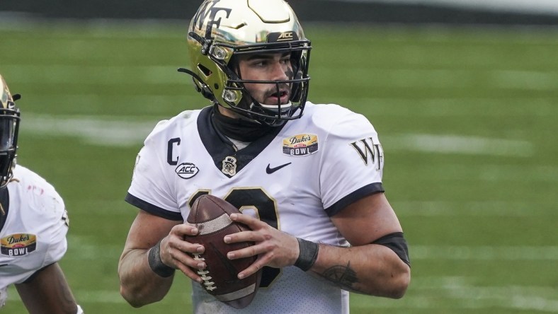 Dec 30, 2020; Charlotte, NC, USA; Wake Forest Demon Deacons quarterback Sam Hartman (10) drops back to pass against the Wisconsin Badgers during second half action at Bank of America Stadium. Mandatory Credit: Jim Dedmon-USA TODAY Sports