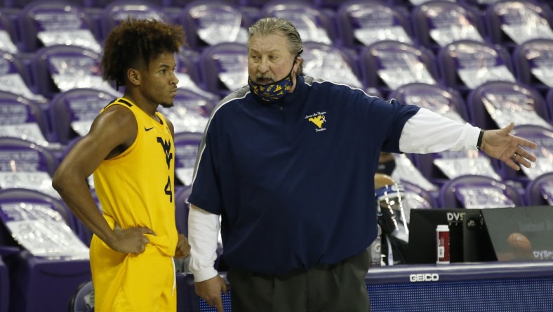Feb 23, 2021; Fort Worth, Texas, USA; West Virginia Mountaineers head coach Bob Huggins talks to guard Miles McBride (4) during the second half against the TCU Horned Frogs at Ed and Rae Schollmaier Arena. Mandatory Credit: Tim Heitman-USA TODAY Sports