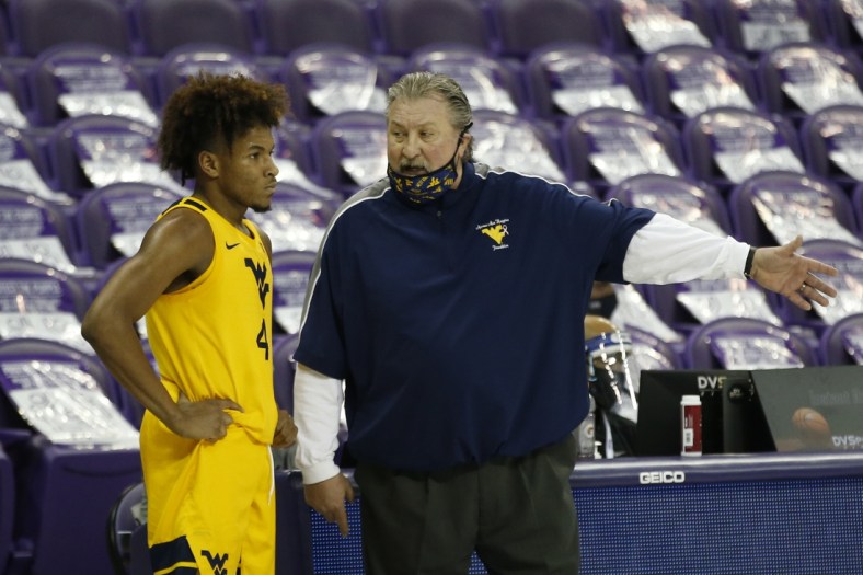 Feb 23, 2021; Fort Worth, Texas, USA; West Virginia Mountaineers head coach Bob Huggins talks to guard Miles McBride (4) during the second half against the TCU Horned Frogs at Ed and Rae Schollmaier Arena. Mandatory Credit: Tim Heitman-USA TODAY Sports