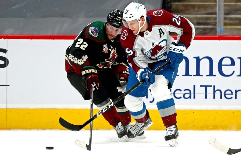 Feb 26, 2021; Glendale, Arizona, USA; Arizona Coyotes left wing Johan Larsson (22) and Colorado Avalanche defenseman Dennis Gilbert (9) go for the puck during the first period at Gila River Arena. Mandatory Credit: Mark J. Rebilas-USA TODAY Sports
