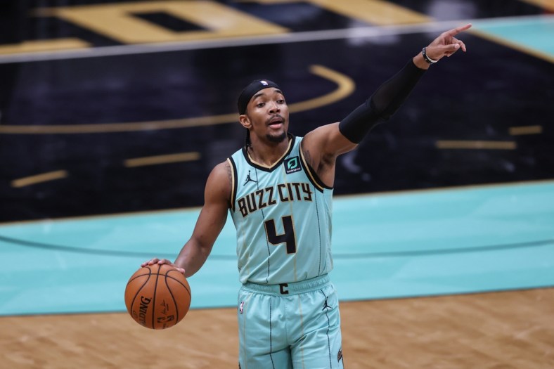 Apr 25, 2021; Charlotte, North Carolina, USA; Charlotte Hornets guard Devonte' Graham (4) directs his team against the Boston Celtics in the first half at Spectrum Center. The Charlotte Hornets won 125-104. Mandatory Credit: Nell Redmond-USA TODAY Sports
