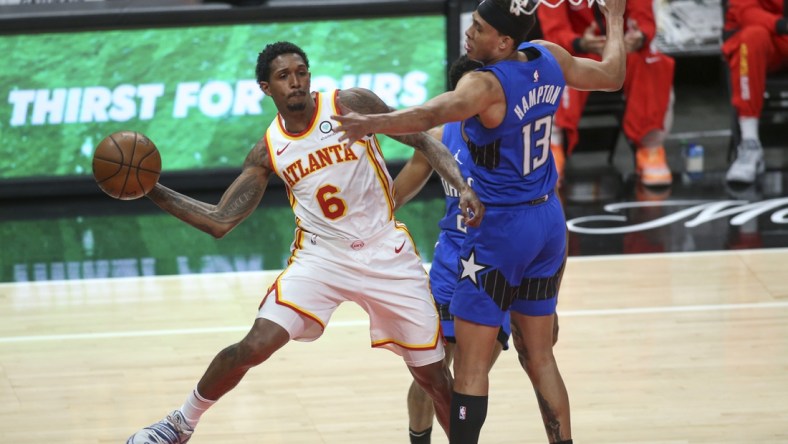 May 13, 2021; Atlanta, Georgia, USA; Atlanta Hawks guard Lou Williams (6) passes the ball around Orlando Magic guard R.J. Hampton (13) during the fourth quarter at State Farm Arena. Mandatory Credit: Brett Davis-USA TODAY Sports