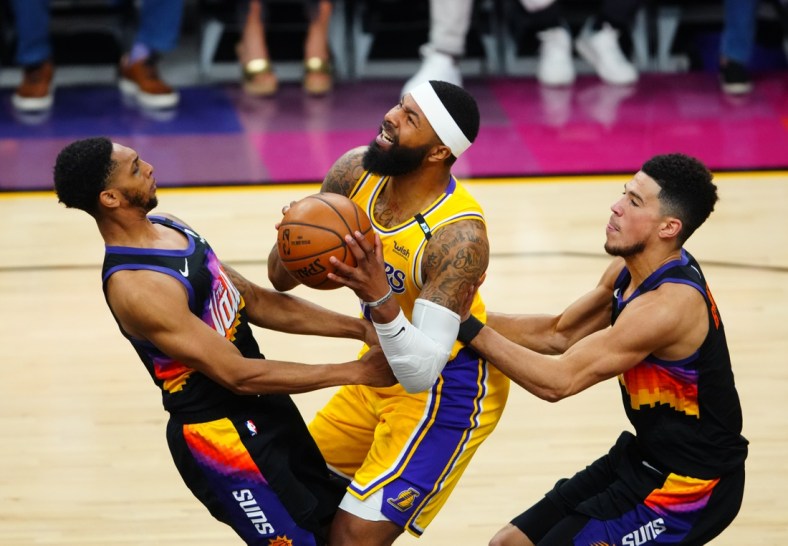 May 25, 2021; Phoenix, Arizona, USA; Los Angeles Lakers forward Markieff Morris (center) drives to the basket against Phoenix Suns guard Cameron Payne (left) and Devin Booker during game two of the first round of the 2021 NBA Playoffs at Phoenix Suns Arena. Mandatory Credit: Mark J. Rebilas-USA TODAY Sports