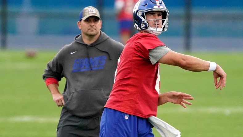 New York Giants quarterback Daniel Jones (8) throws the ball as head coach Joe Judge looks on during OTA practice at the Quest Diagnostics Training Center on Friday, June 4, 2021, in East Rutherford.Giants Ota Practice