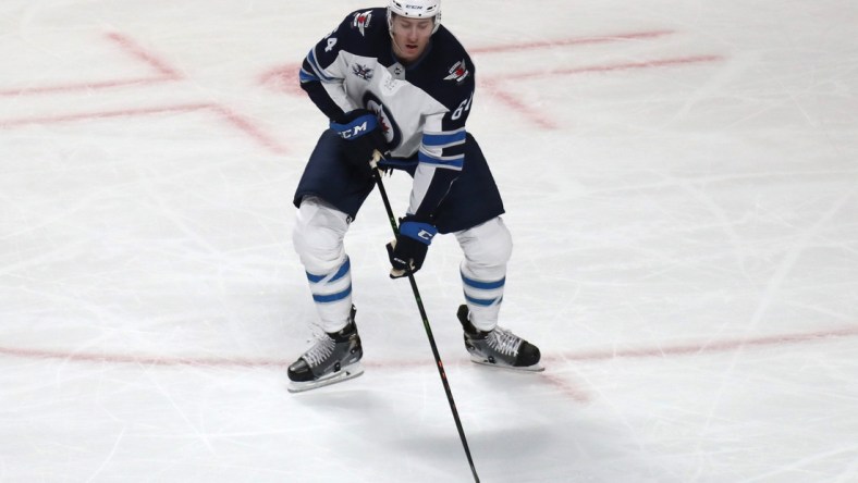 Jun 7, 2021; Montreal, Quebec, CAN; Winnipeg Jets defenseman Logan Stanley (64) plays the puck against Montreal Canadiens during the second period in game four of the second round of the 2021 Stanley Cup Playoffs at Bell Centre. Mandatory Credit: Jean-Yves Ahern-USA TODAY Sports