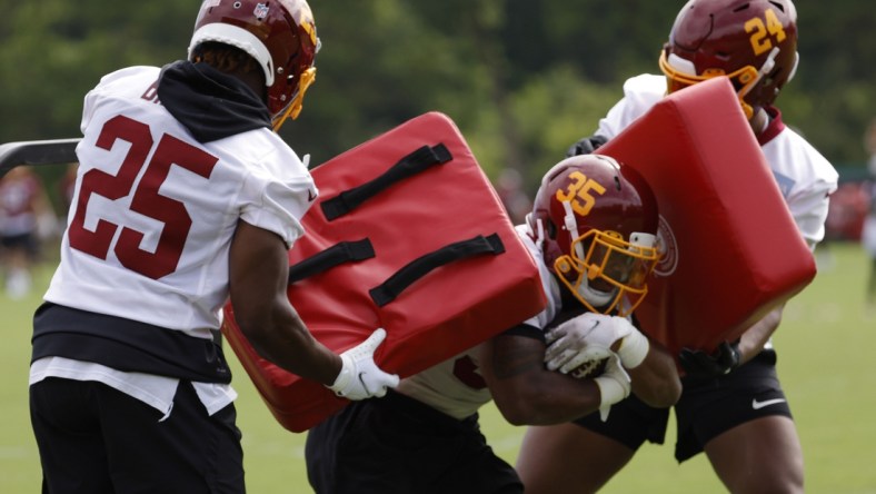 Jun 10, 2021; Ashburn, VA, USA; Washington Football Team running back Lamar Miller (35) carries the ball between Washington Football Team running back Payton Barber (25) and Washington Football Team running back Antonio Gibson (24) during drills as part of minicamp at Inova Sports Performance Center. Mandatory Credit: Geoff Burke-USA TODAY Sports