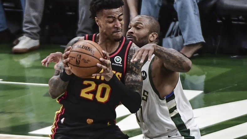 Jul 1, 2021; Milwaukee, Wisconsin, USA; Atlanta Hawks forward John Collins (20) gets pressure from Milwaukee Bucks forward P.J. Tucker (17) in the first quarter during game five of the Eastern Conference Finals for the 2021 NBA Playoffs at Fiserv Forum. Mandatory Credit: Benny Sieu-USA TODAY Sports