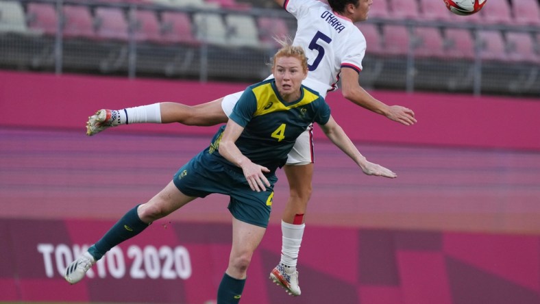 Jul 27, 2021; Ibaraki, Japan; Australia player Clare Polkinghorne (4) and USA player Kelley O'Hara (5) go for a header during the Tokyo 2020 Olympic Summer Games at Ibaraki Kashima Stadium. Mandatory Credit: Jack Gruber-USA TODAY Sports